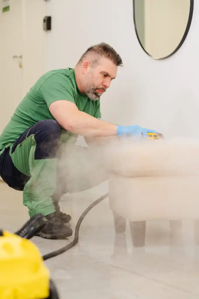 Flekkfjerning Oslo – tekniker fjerner flekk fra tekstilsofa med rensemaskin