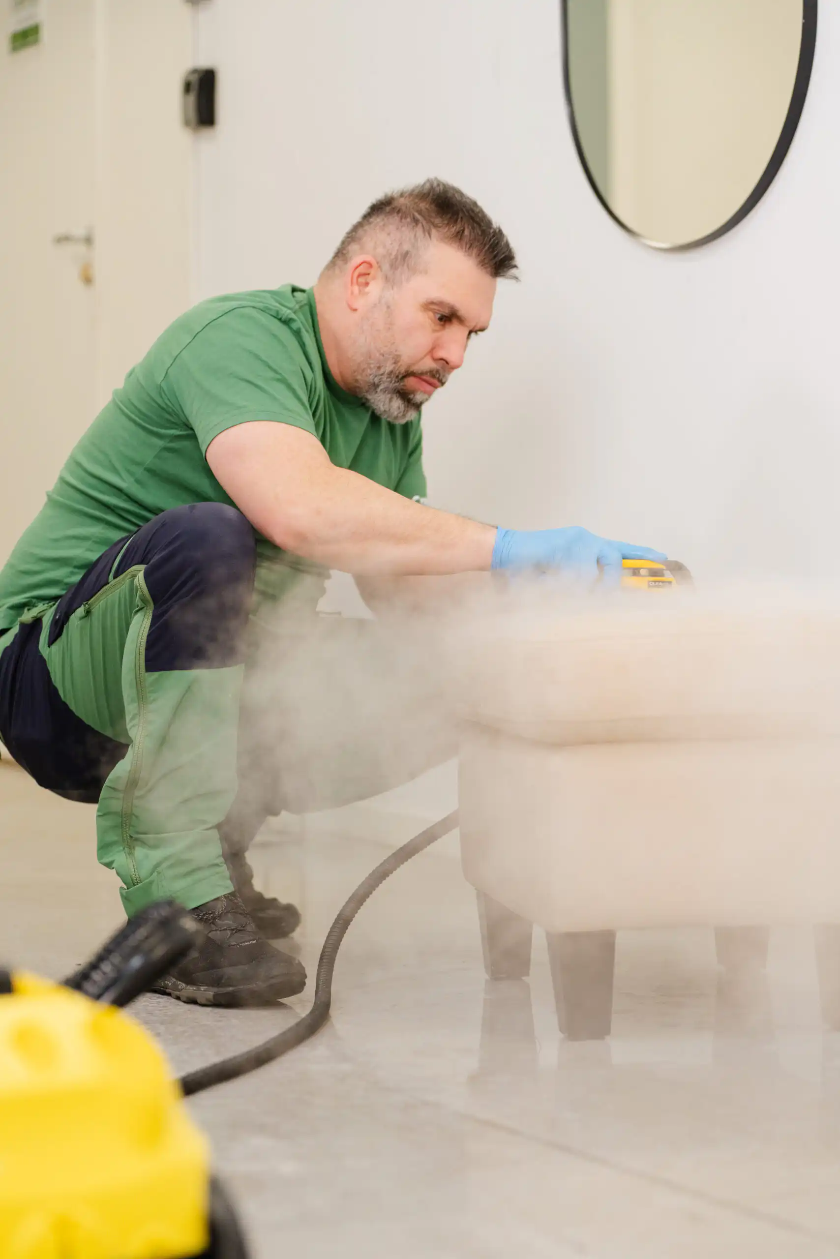 Flekkfjerning Oslo – tekniker fjerner flekk fra tekstilsofa med rensemaskin